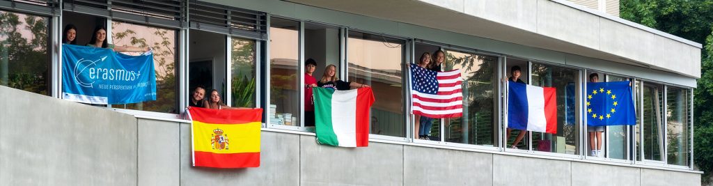 Mehrere Schüler halten Flaggen aus den Schulklassen